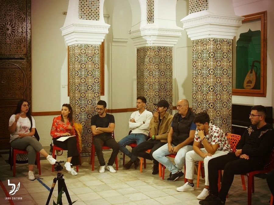 A debate session in progress with an Ach Banlek banner