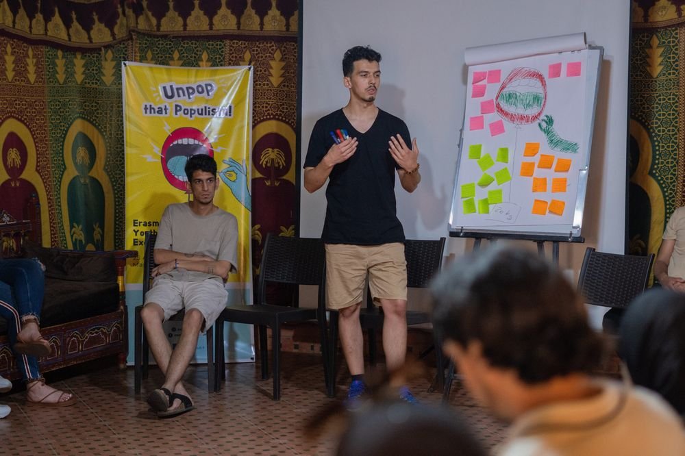 A facilitator leading a non-formal education session with flipcharts